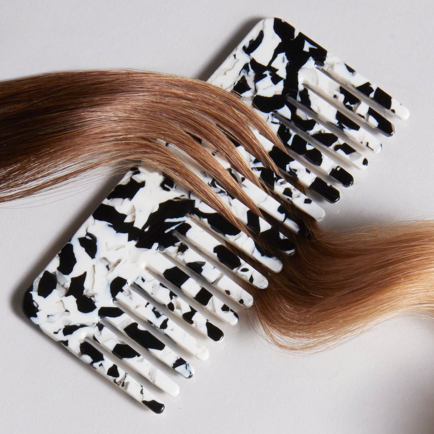 Editorial products of comb with strands of hair in between the teeth