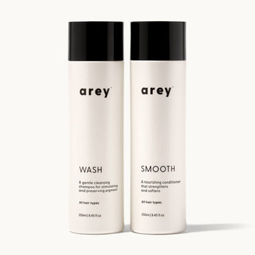 Two bottles of 'arey' hair care products on a white background