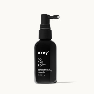 Black serum bottle labeled 'To The Root' on a white background image