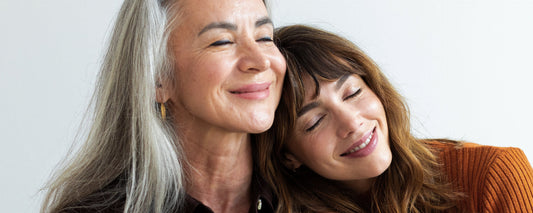 Daughter leans on mom with grey hair