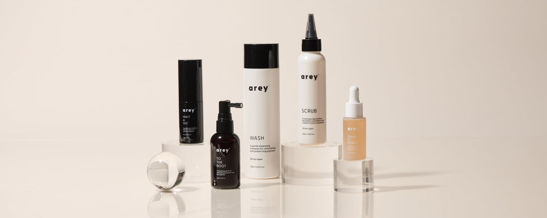 A collection of bottles of Arey haircare that works like skincare with Mela-9® Complex