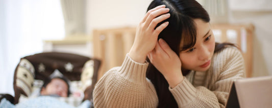 Woman with new baby checks her hair for postpartum hair loss