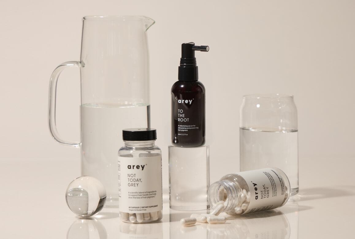 Collection of arey products including a pitcher, bottles, and jars on a light background