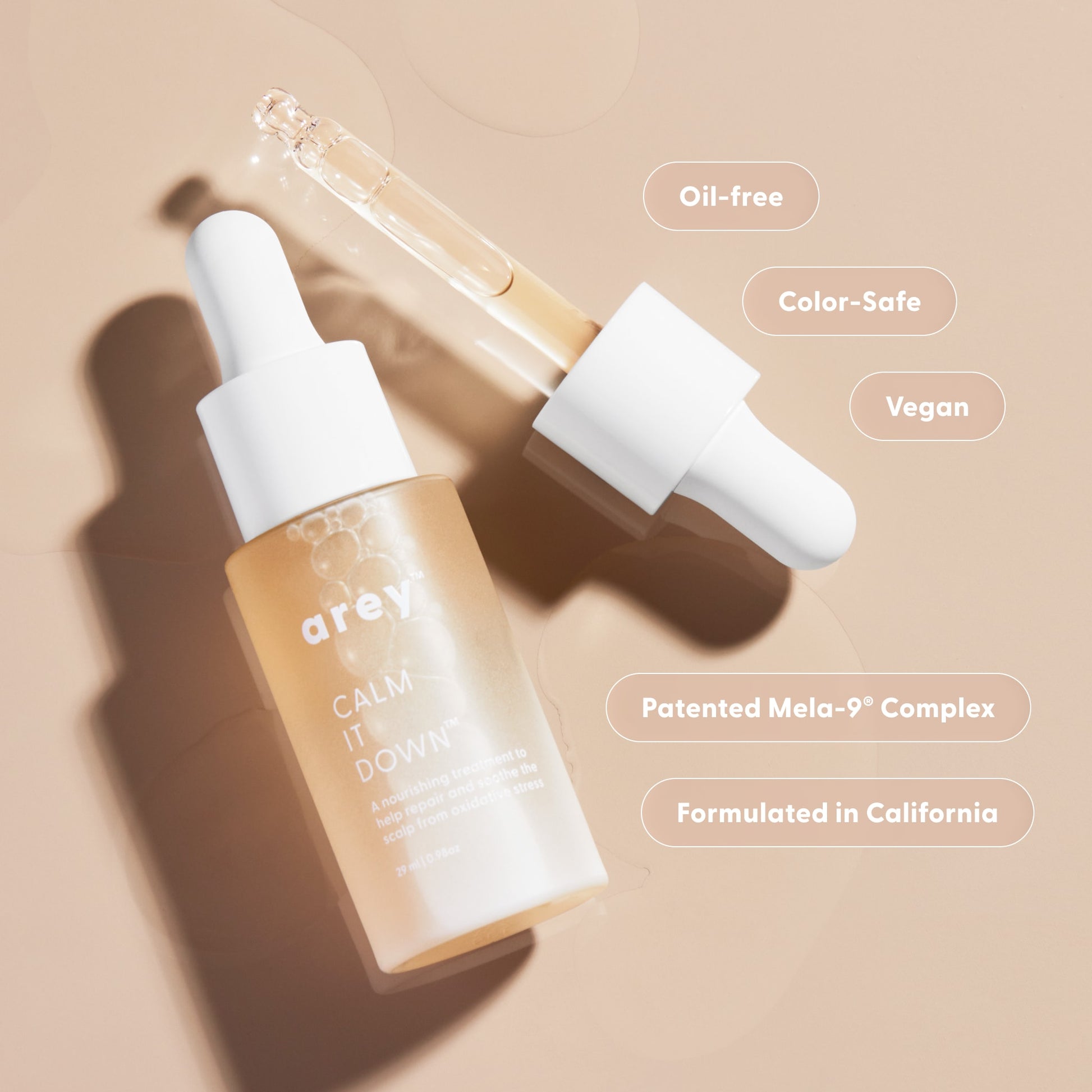 haircare dropper bottle with dropper on a beige background, featuring product details.