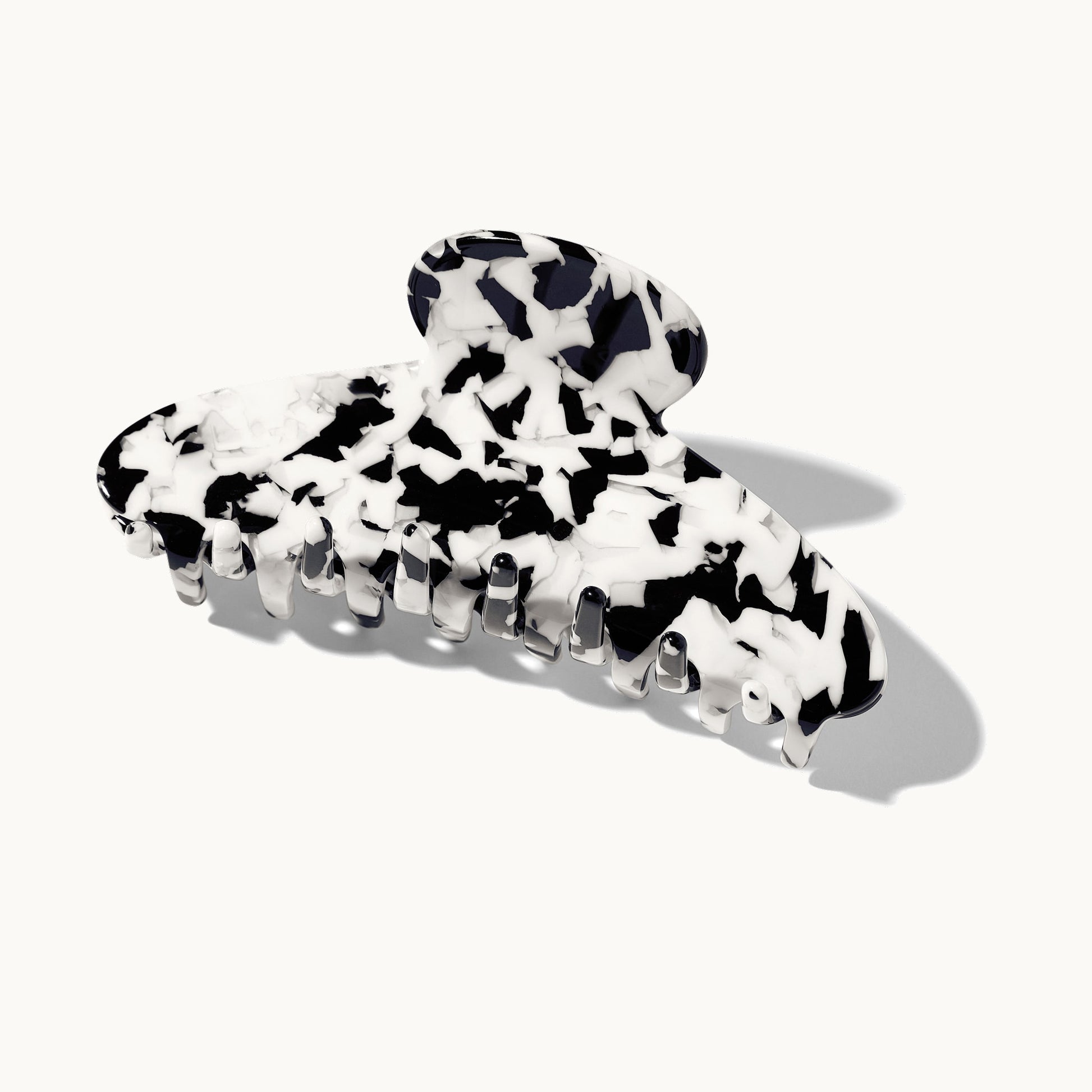 Product shot of the arey claw clip in black and white tortoiseshell pattern on a white background, shown closed from a 3/4 angle.