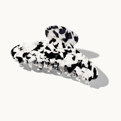 Product shot of the arey claw clip in black and white tortoiseshell pattern on a white background, shown closed from a 3/4 angle.