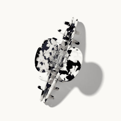 Product shot of the arey tortoiseshell hair clip in black and white pattern on a white background, shown open with the spring hinge mechanism visible.