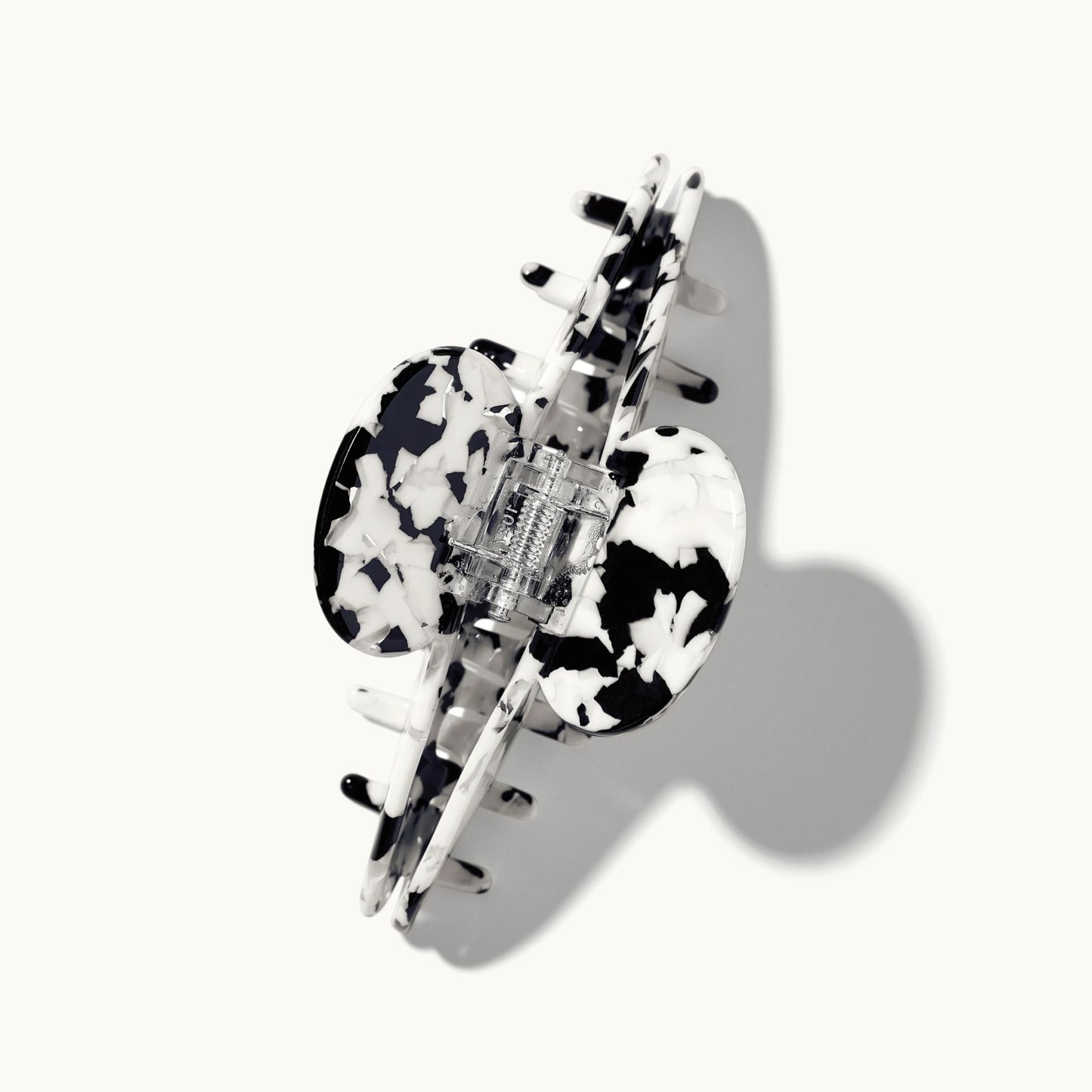 Product shot of the arey tortoiseshell hair clip in black and white pattern on a white background, shown open with the spring hinge mechanism visible.