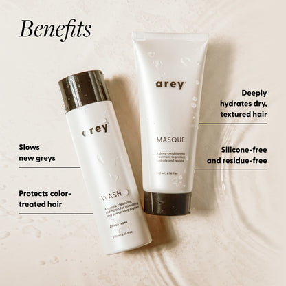 Benefits infographic for the Arey Deep Treatment Duo (Wash + Masque) with both products displayed on a wet surface. Benefits: Deeply hydrates dry, textured hair; Slows new greys; Silicone-free and residue-free; Protects color-treated hair.