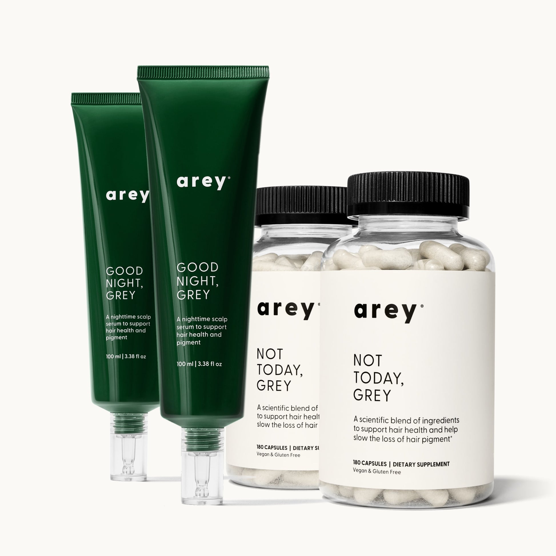 Arey Dream Duo 6-Month Supply. Two green tubes labeled "arey / GOOD NIGHT, GREY / A nighttime scalp serum to support hair health and pigment / 100 ml | 3.38 fl oz." Two clear bottles labeled "arey / NOT TODAY, GREY / A scientific blend of ingredients to support hair health and help slow the loss of hair pigment* / 180 CAPSULES | DIETARY SUPPLEMENT / Vegan & Gluten Free."