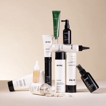 Flat-lay product photo of the full Arey hair care collection including Good Night Grey, To The Root, Mend, Scrub, Smooth, Wash, Calm It Down, Masque, Wait & See, and Live In Mist products against a neutral background