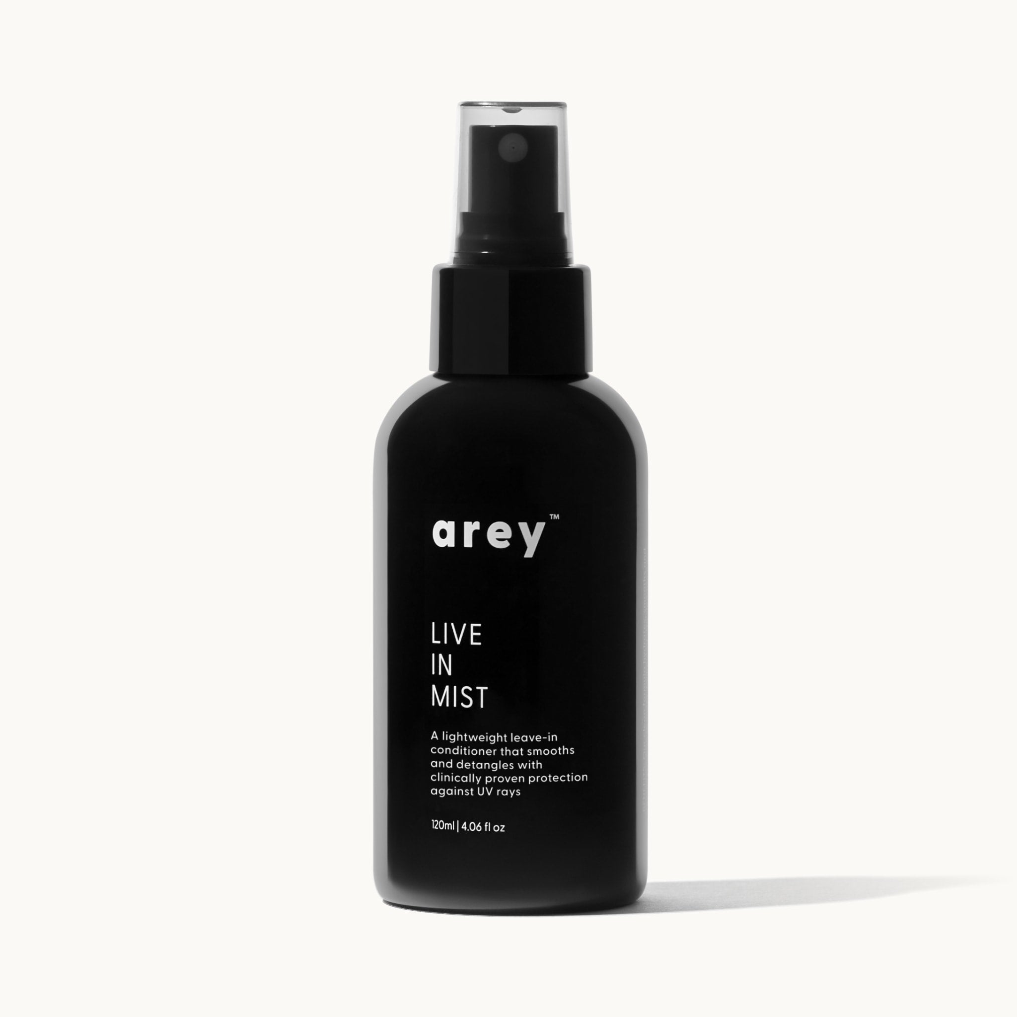 Product shot of arey Live In Mist dark glass spray bottle on a white/cream background. Label reads: arey™ LIVE IN MIST — 