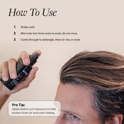 Person holding a hair product spray with usage instructions on a beige background