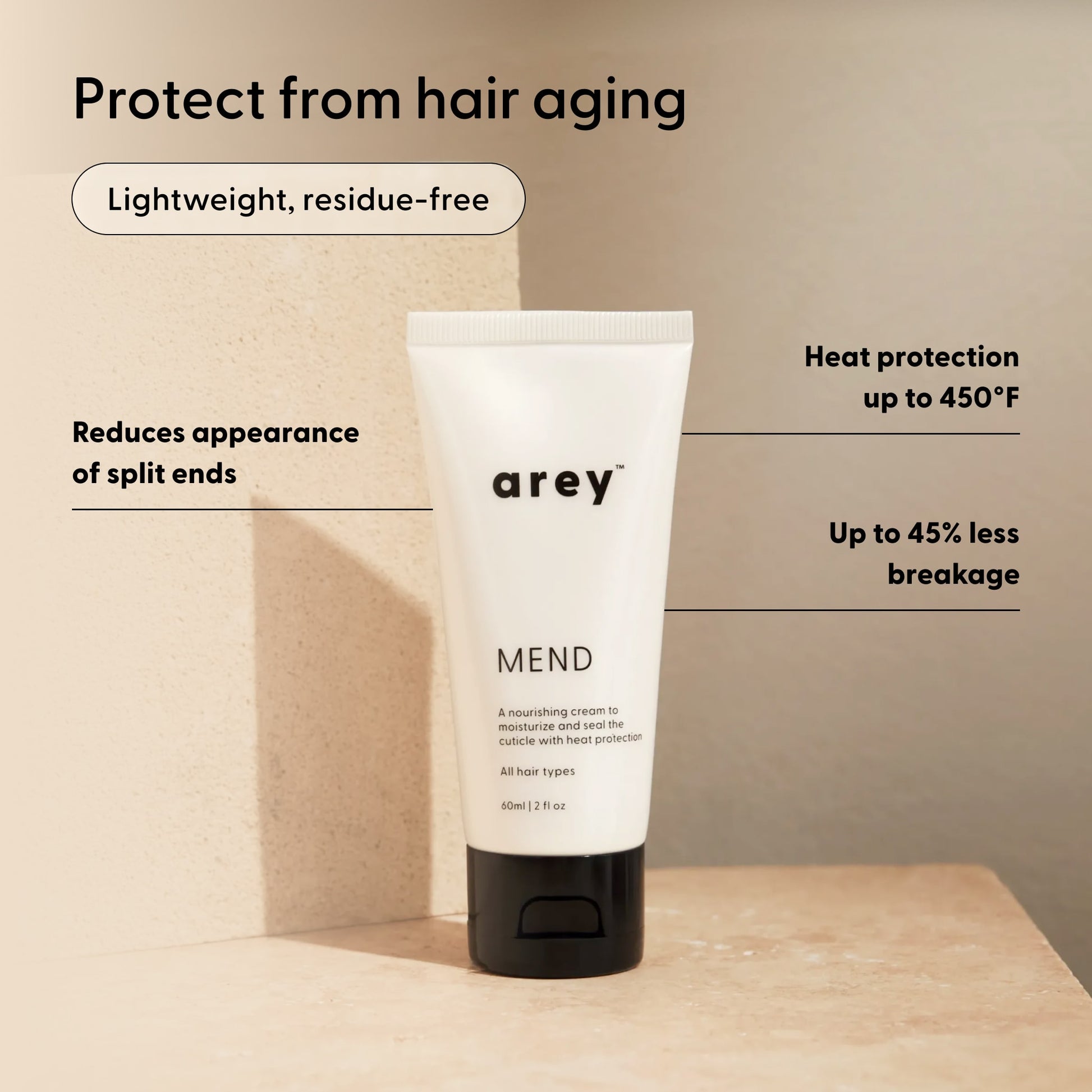A white tube labeled Arey Mend Heat Protectant Leave-In stands on a beige surface with text highlighting its benefits: reduces split ends, provides heat protection up to 450°F, results in up to 45% less hair breakage, is lightweight and residue-free. Formulated with vegan collagen for healthier-looking hair.