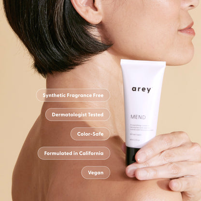 Person holding a tube of 'arey' haircare product with product features listed.