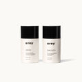 Two Arey Mini Duo travel-size bottles side by side on a white background. Left: arey® Wash — "A gentle cleansing shampoo for stimulating and preserving pigment", All hair types, 100ml/3.3 fl oz. Right: arey® Smooth — "A nourishing conditioner that strengthens and softens", All hair types, 100ml/3.3 fl oz.