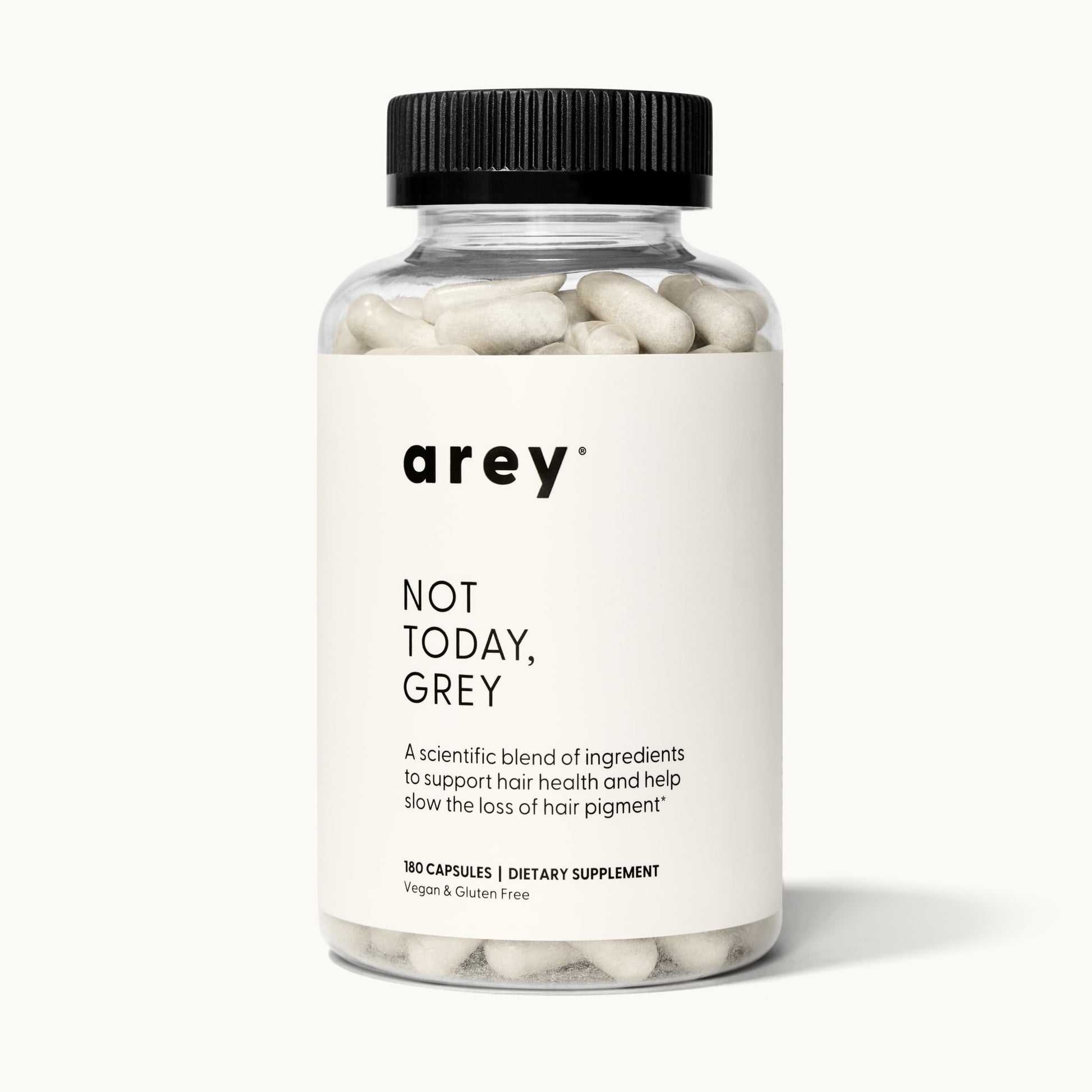 Product shot of the Arey Not Today Grey 3-month supply bottle on a white/cream background. Label reads: arey® Not Today, Grey. "A scientific blend of ingredients to support hair health and help slow the loss of hair pigment.†" 180 Capsules, Dietary Supplement, Vegan & Gluten Free.