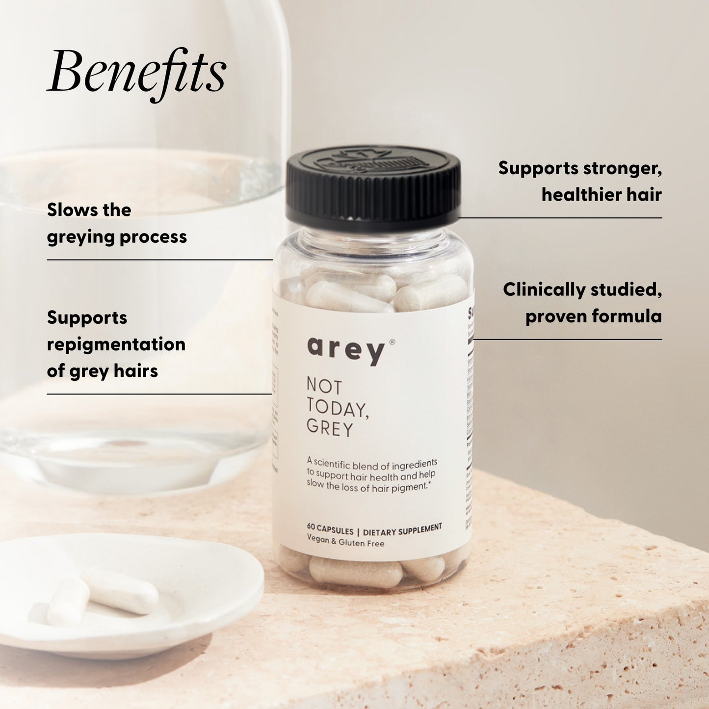 "Benefits" infographic for Arey Not Today Grey showing the product bottle on a stone surface with a white dish and capsules. Benefits listed: Slows the greying process; Supports repigmentation of grey hairs; Supports stronger, healthier hair; Clinically studied, proven formula. Product label reads: arey® Not Today, Grey. "A scientific blend of ingredients to support hair health and help slow the loss of hair pigment." 60 Capsules, Dietary Supplement, Vegan & Gluten Free.