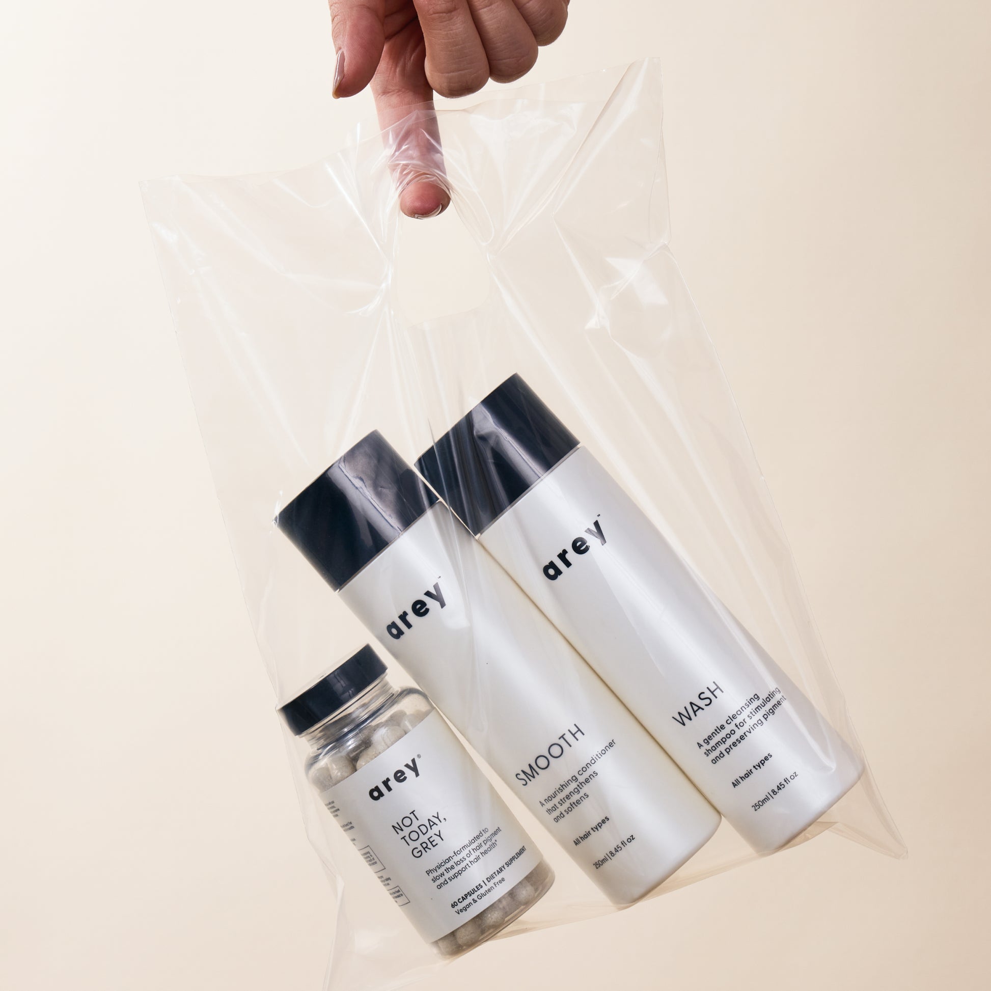 Lifestyle imagery of Wash, Smooth, and Not Today, Grey in a clear plastic bag