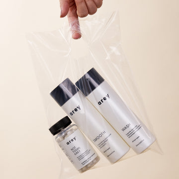 Lifestyle imagery of Wash, Smooth, and Not Today, Grey in a clear plastic bag