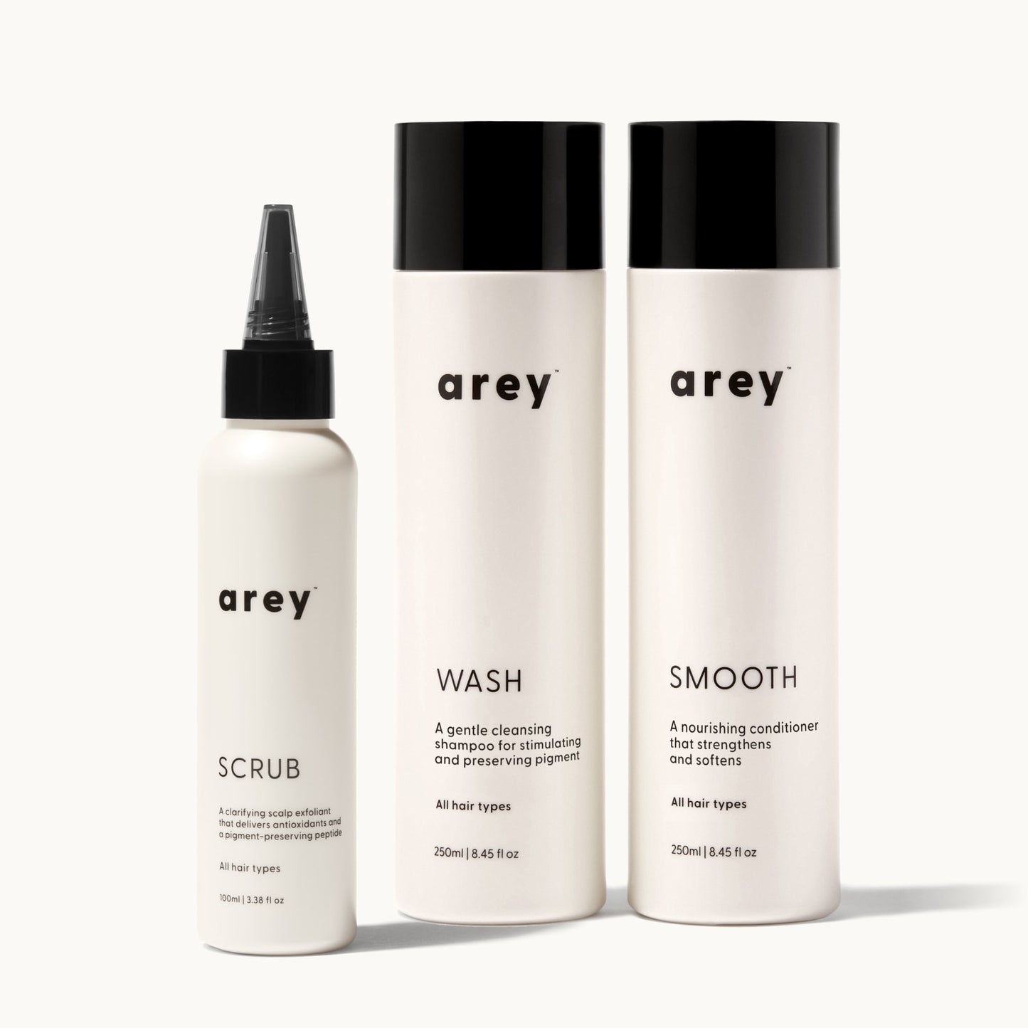 Set of arey hair care products including scrub, wash, and smooth on a white background