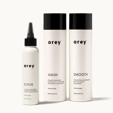 Set of arey hair care products including scrub, wash, and smooth on a white background