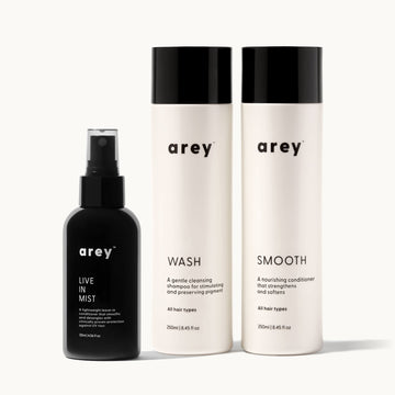 Set of arey hair care products including live in mist, wash, and smooth on a white background