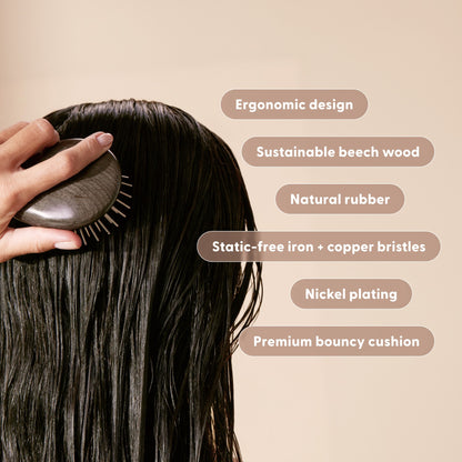 Woman holding the Arey Scalp Brush with value props labeled. Labels: Ergonomic design. Sustainable beech wood. Natural rubber. Nickel plating. Static-free Iron and copper bristles. Premium bouncy cushion