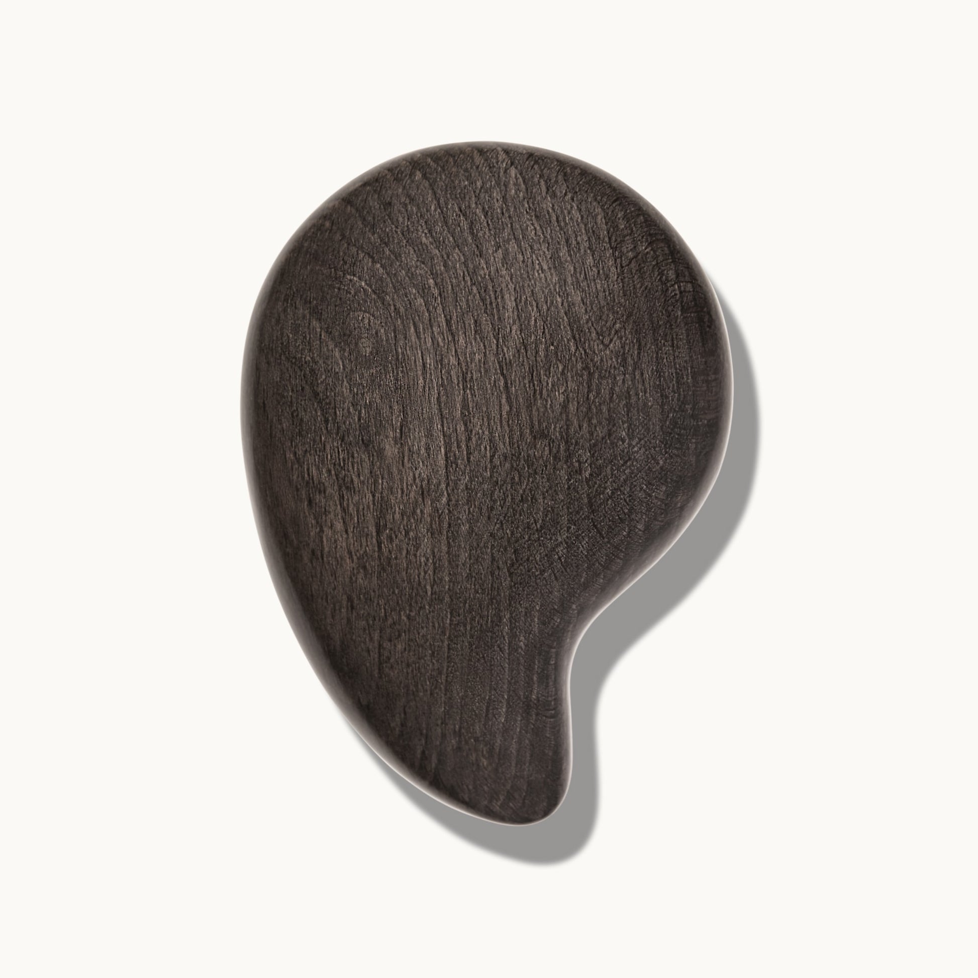 Arey Scalp Brush seen from above on a cream background, showing the dark wood-textured oval brush with curved handle design.