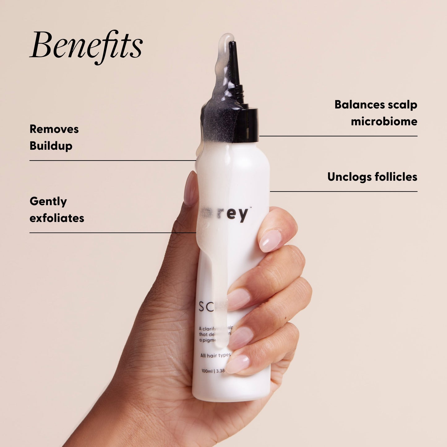 Arey Scalp Scrub bottle held in a hand with benefits labeled. Text reads: Benefits — Removes Buildup. Gently exfoliates. Balances scalp microbiome. Unclogs follicles.
