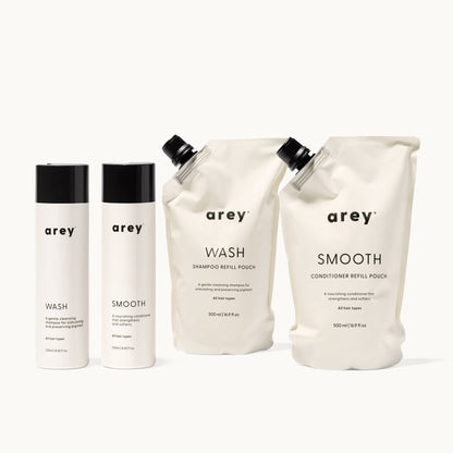 Set of arey hair care products including bottles and pouches on a white background
