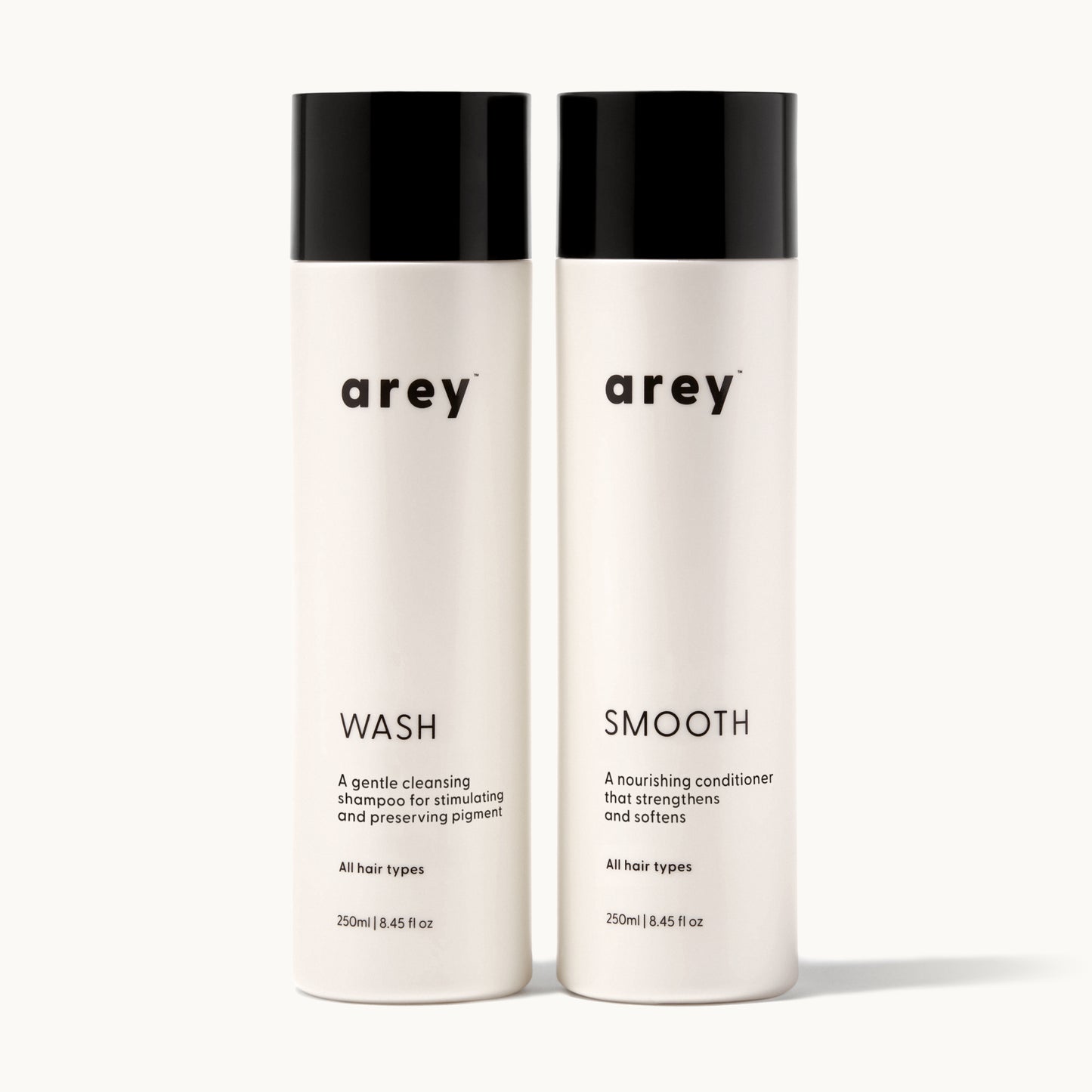 Two bottles of 'arey' hair care products on a white background