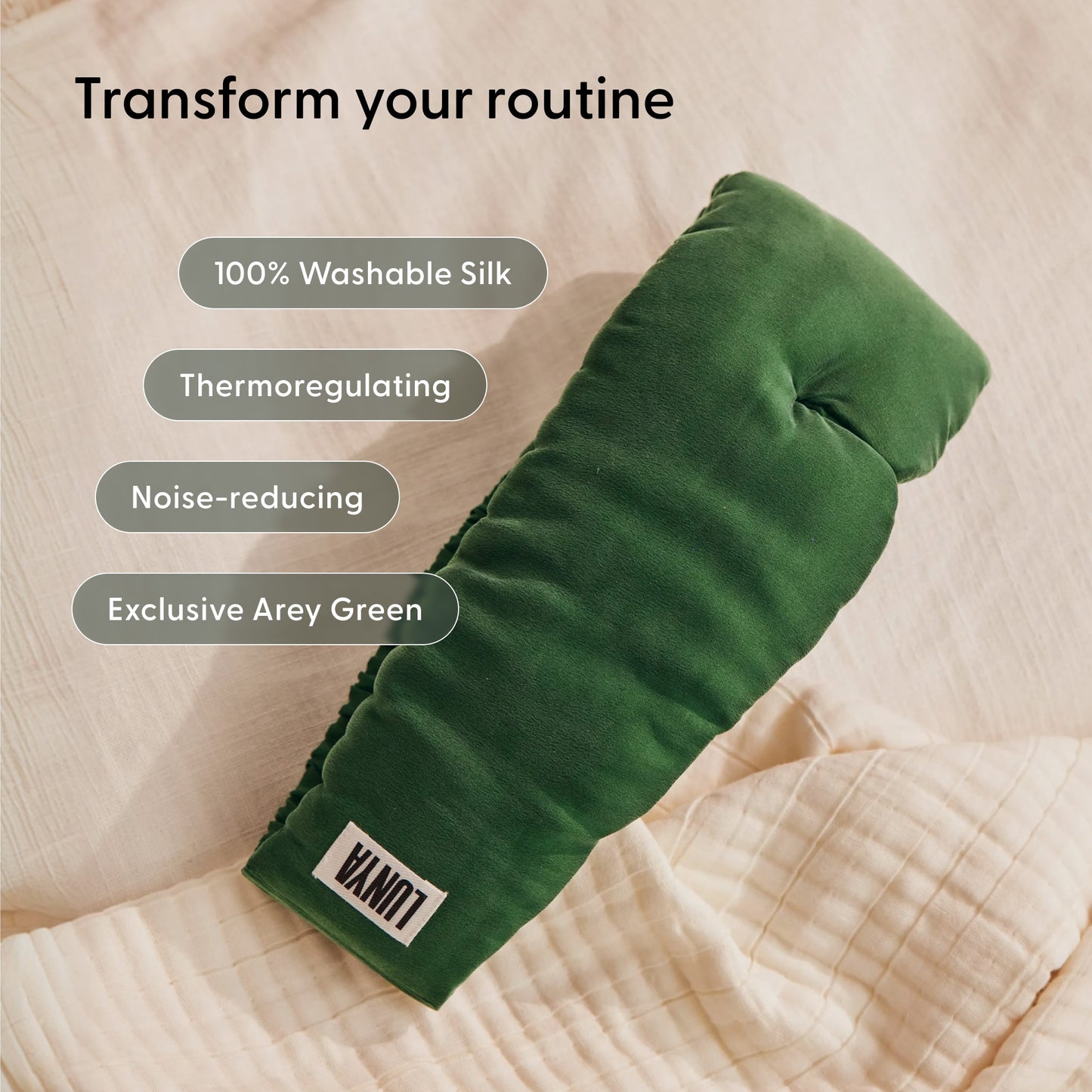 A green silk eye mask from Arey’s The Sleep Ritual Set rests on a beige quilt, with text spotlighting its features: washable silk, thermoregulating properties, noise reduction, and an exclusive Arey Green color—making it the ideal companion to your overnight scalp serum routine for an elevated hair wellness experience.