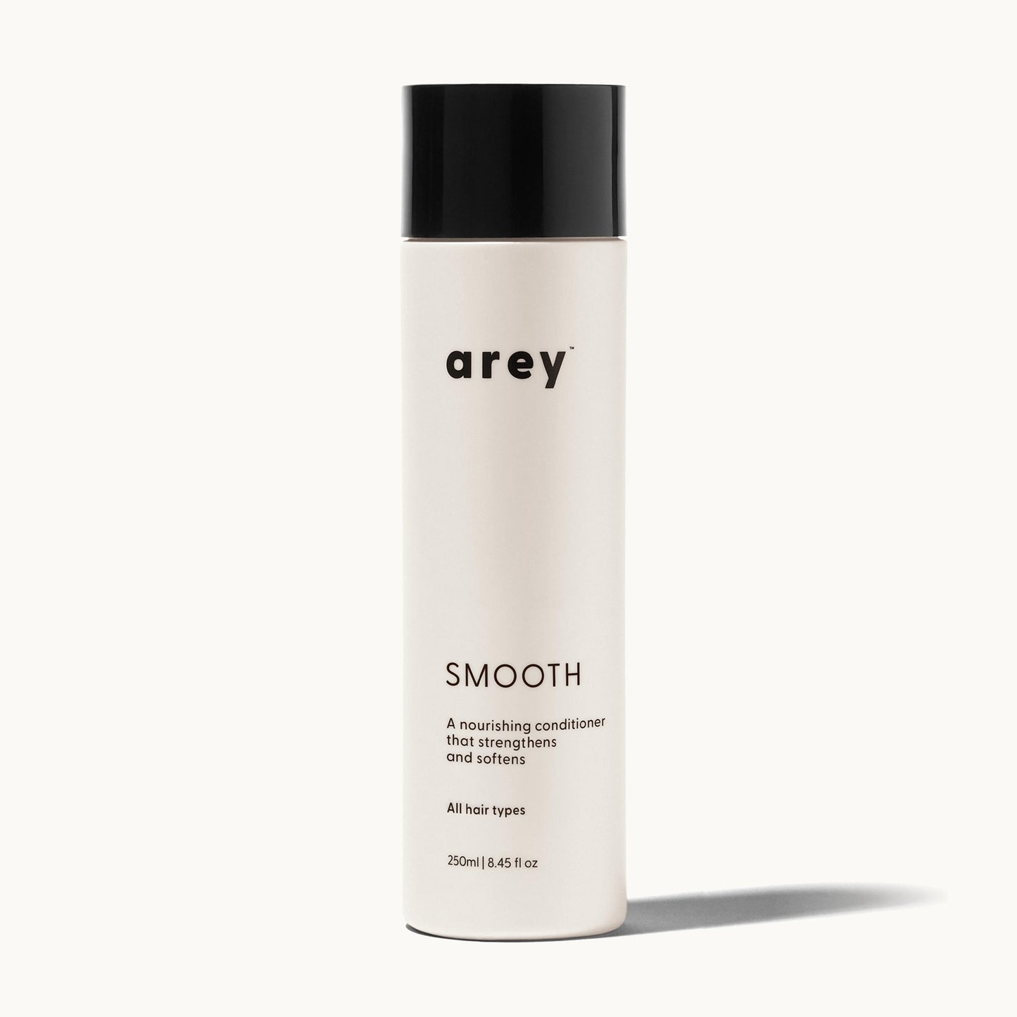 Arey Smooth Conditioner bottle on a cream background. Label reads: arey. SMOOTH. A nourishing conditioner that strengthens and softens. All hair types. 250ml / 8.45 fl oz.