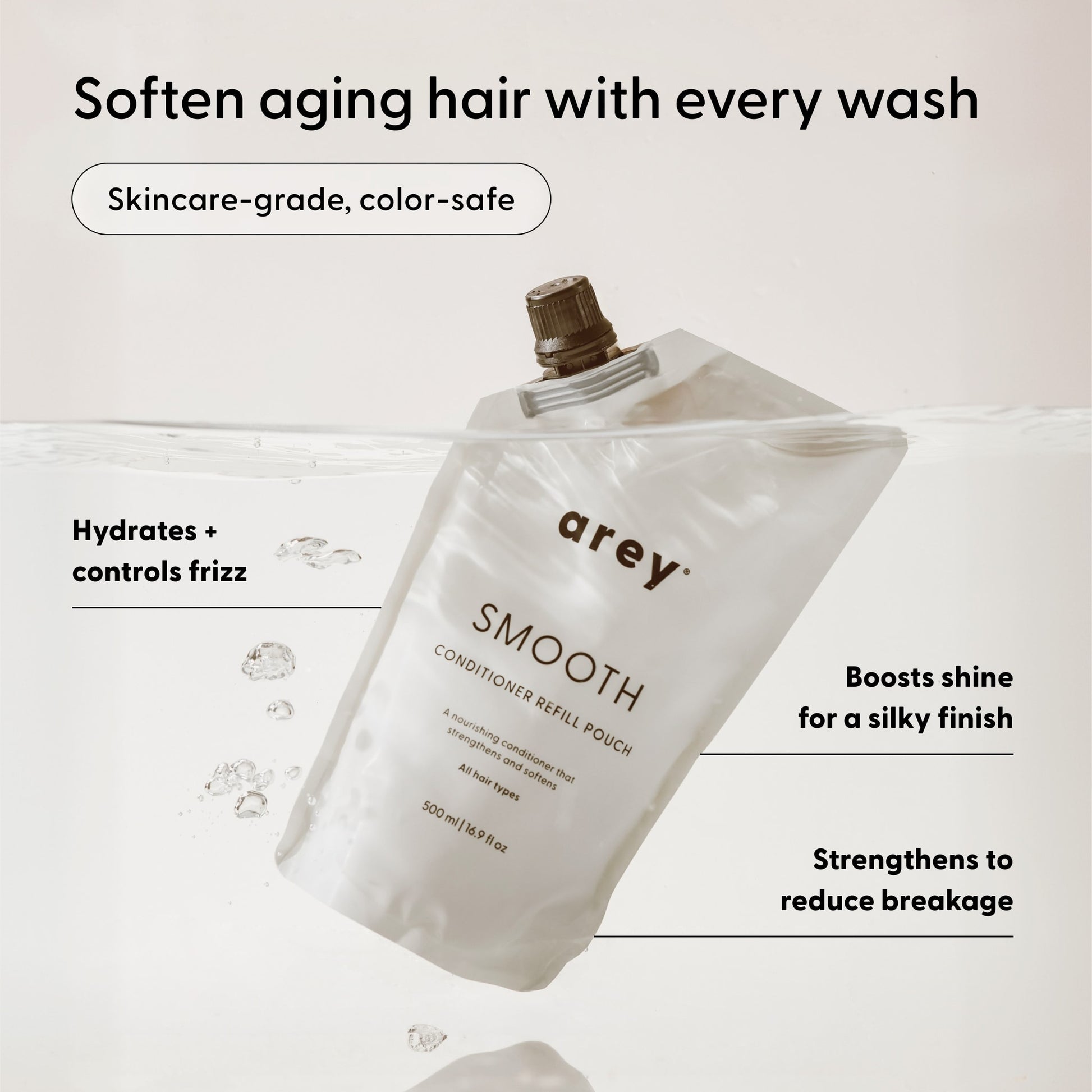 An Arey Smooth Conditioner Refill pouch submerged in water, showcasing key benefits: hydrates, controls frizz, boosts shine, reduces breakage, is color-safe, and suitable for aging hair—this nourishing conditioner from Arey provides advanced hair repair with a clean formula for healthier-looking hair.