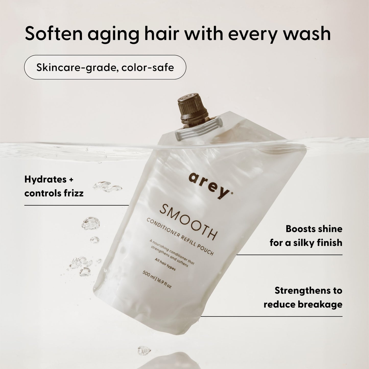 An Arey Smooth Conditioner Refill pouch submerged in water, showcasing key benefits: hydrates, controls frizz, boosts shine, reduces breakage, is color-safe, and suitable for aging hair—this nourishing conditioner from Arey provides advanced hair repair with a clean formula for healthier-looking hair.