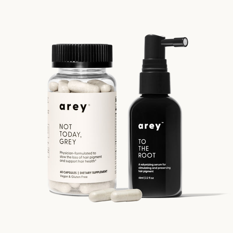 Arey Not Today, Grey and To The Root products on a cream background. Left: Arey Not Today, Grey supplement bottle (60 capsules, Dietary Supplement, Vegan & Gluten Free) with capsules displayed in front. Right: Arey To The Root serum bottle (66ml / 2.2 fl oz), a volumizing serum for stimulating and preserving hair pigment.