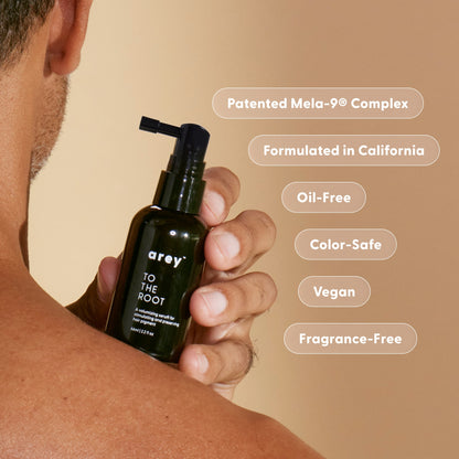 Hand holding the Arey To The Root serum bottle, with clean formula certifications listed. Text reads: Patented Mela-9® Complex. Formulated in California. Oil-Free. Color-Safe. Vegan. Fragrance-Free.