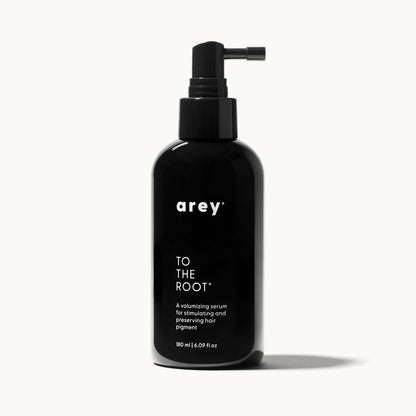 Single Arey To The Root serum bottle on a cream background, representing a 3-month supply. Bottle labeled: arey. TO THE ROOT. A volumizing serum for stimulating and preserving hair pigment. 180 ml / 6.09 fl oz.