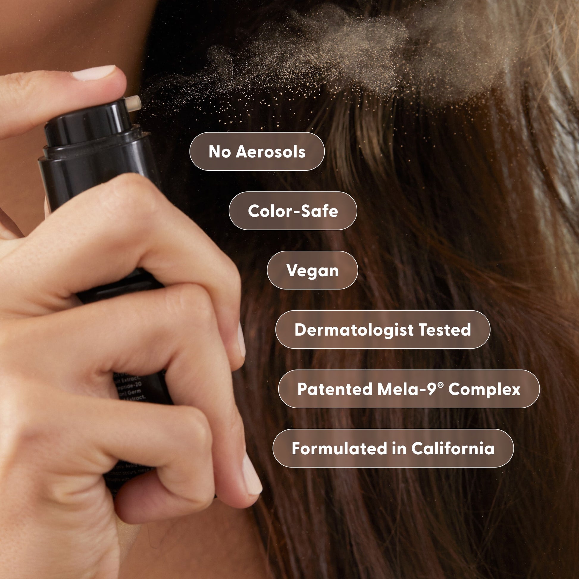 A person sprays Arey Wait A Sec® Dry Shampoo—a non-aerosol formula—onto brown hair. Text bubbles read: Absorb Oil, Boost Volume, No Aerosols, Color-Safe, Vegan, Dermatologist Tested, Patented Mela-9® Complex, Formulated in California.