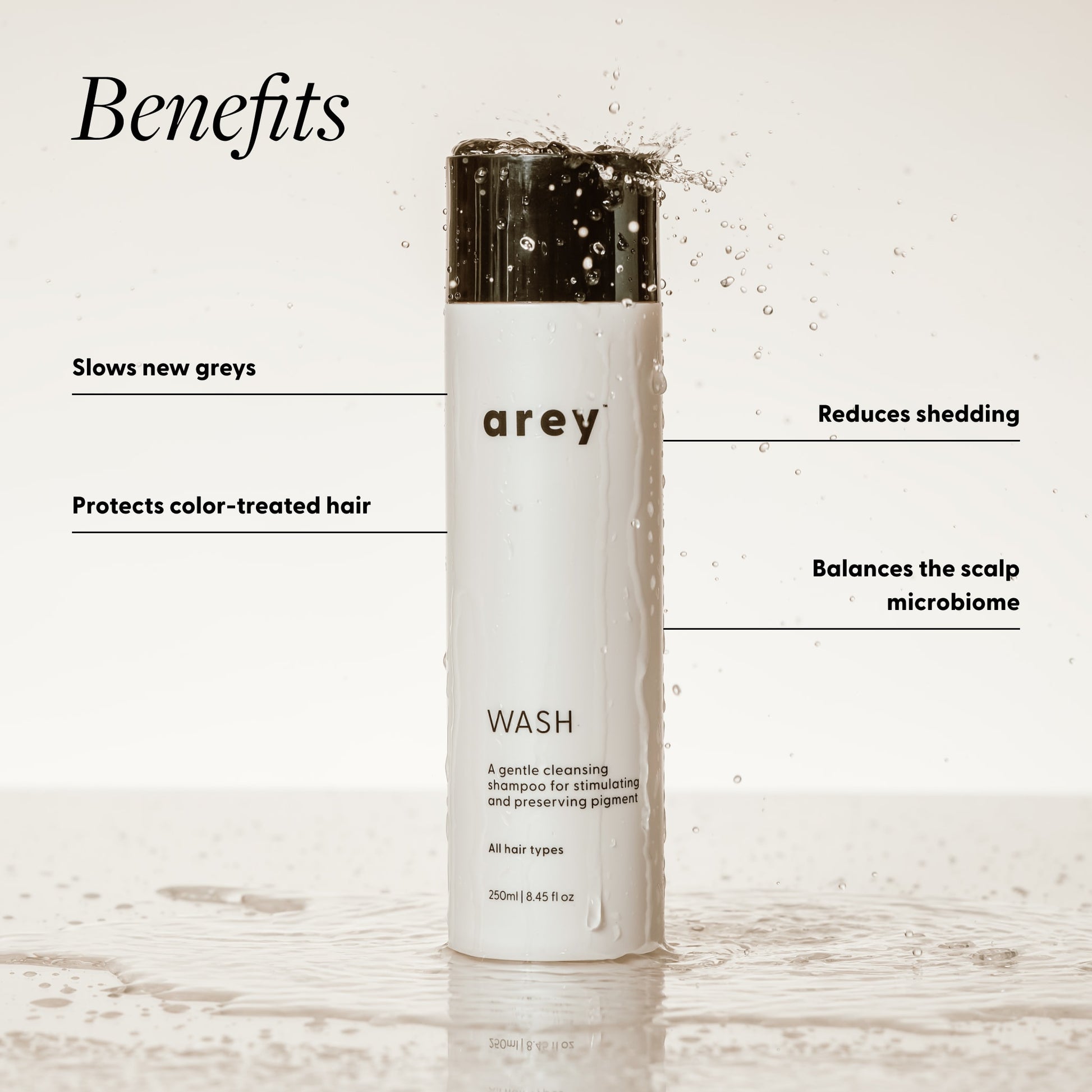 Shampoo bottle labeled 'arey' with benefits listed on a light background