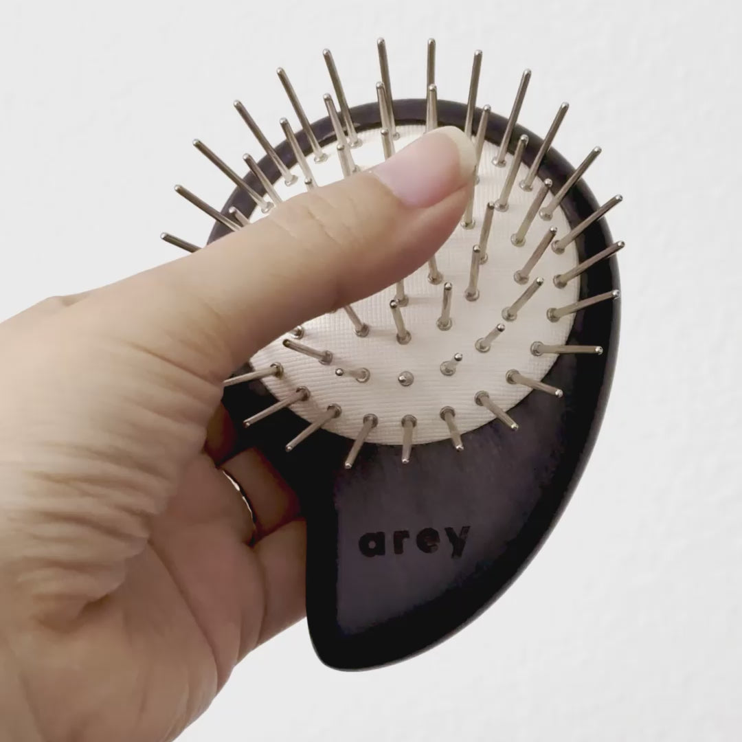Short video showing someone pressing into the brush to illustrate the premium bouncy cushion behind the static-free iron and copper bristles.