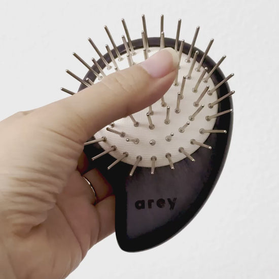 Short video showing someone pressing into the brush to illustrate the premium bouncy cushion behind the static-free iron and copper bristles.