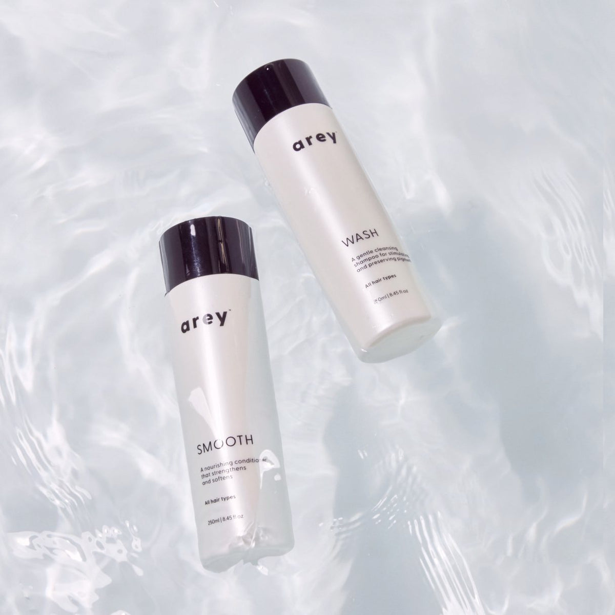 Arey Wash and Smooth bottles floating in water.