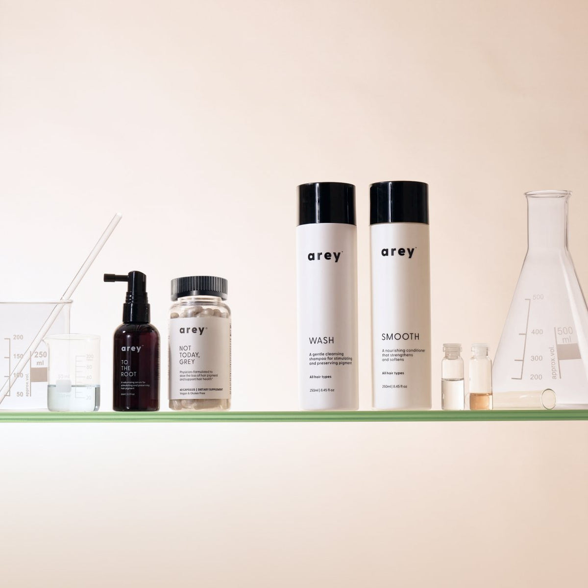 Arey products on a lab shelf between glass beakers and a flask.